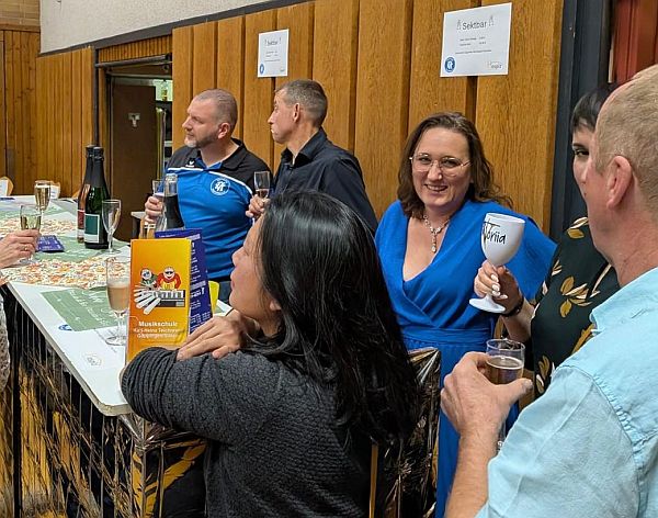 Personen vor und hinter der Bar