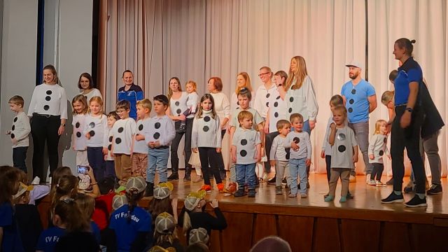 Eltern-Kind-Gruppe in Schneemann-Kostümen auf der Bühne