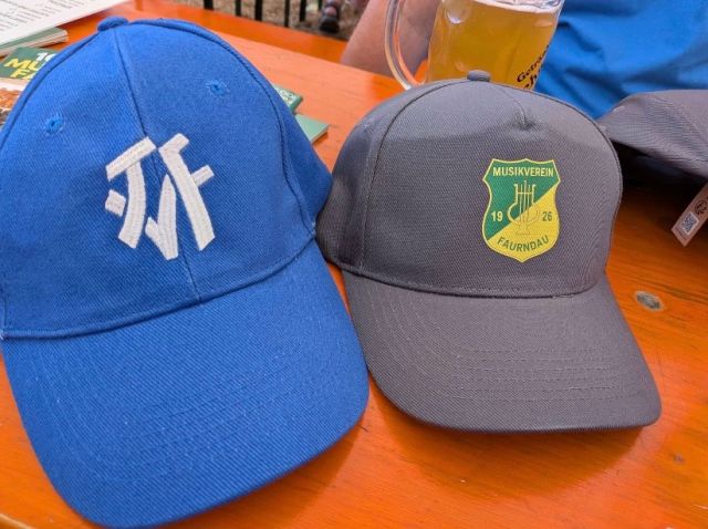 Auf der Bierbank liegen zwei Cappys eine vom TVF und eine Geschenk Cappy vom MVF
