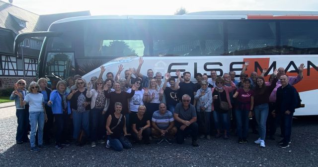 Gruppenbild mit 46 Personen vor dem Reisebus